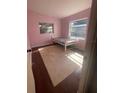 Cozy bedroom showcasing hardwood floors, two windows, and a twin bed frame at 116 Main St, Windermere, FL 34786