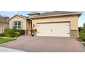 Brick paver driveway and two-car garage, well-maintained landscaping at 17833 Blazing Star Cir, Clermont, FL 34714