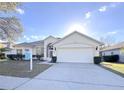 Single-story house with a two-car garage, landscaping, and a For Sale sign at 2485 Huron Cir, Kissimmee, FL 34746