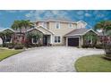 Spacious two-story home with stone accents, a driveway, a two-car garage, and tropical landscaping at 3301 Buckingham Way, St Cloud, FL 34772