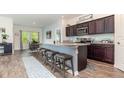 Open kitchen with granite counters, breakfast bar seating, stainless appliances and wood-look flooring at 538 Stowers Dr, New Smyrna Beach, FL 32168