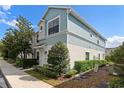 Attractive two-story townhome with a blend of light stucco and blue accents, complemented by lush landscaping at 1161 Trillium Park Ln, Sanford, FL 32773