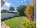 Landscaped backyard with a well-maintained lawn and a white fence at 5138 Andrea Blvd, Orlando, FL 32807