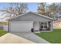 Charming single-Gathering home features a well-manicured lawn, attached garage, and a cozy front porch sitting area at 1208 Old Apopka Rd, Apopka, FL 32703