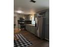 A modern kitchen with stainless steel appliances, light grey cabinets, a backsplash, and wood floors at 1320 S Oleander Ave, Sanford, FL 32771