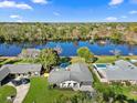 Aerial view of a beautiful home with a large backyard, mature trees, and private lake access at 2631 Falmouth Rd, Maitland, FL 32751