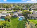 A birds eye view of a backyard with a luxurious pool, well-manicured lawn, and pergola-covered patio at 2631 Falmouth Rd, Maitland, FL 32751