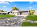 Charming single-story home with a brick paver driveway, lush lawn, and manicured landscaping at 2631 Falmouth Rd, Maitland, FL 32751