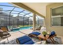 Relaxing screened-in pool area with lounge chairs and patio furniture at 2763 Oxymoron Way, Kissimmee, FL 34746