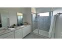 Modern bathroom with double vanity, large shower, and gray tile at 3203 Laurent Loop, Davenport, FL 33837