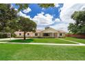 Traditional home featuring a manicured front lawn with a bright and sunny sky behind it at 3651 S Rosalind Ave, Orlando, FL 32806