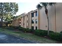 Tan condo building with palm trees and landscaping at 610 Cranes Way # 307, Altamonte Springs, FL 32701