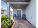 Covered porch with blue door and two rocking chairs at 3570 Southern Cross Loop, Kissimmee, FL 34744