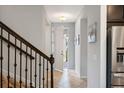 Bright foyer featuring tile floors, staircase with iron railing, and an open doorway to the outside at 1219 Verdant Glade Pl, Winter Park, FL 32792