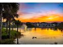 Picturesque pond featuring a fountain and ducks, with residential buildings in the background, all reflected in the water at 1312 Blue Stem Ln, Winter Park, FL 32792