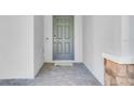 Close-up of a modern front door with a stone pillar and a tiled entryway at 142 Jones Fish Camp Rd, Edgewater, FL 32141