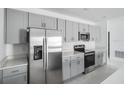 Beautiful kitchen featuring stainless steel appliances, sleek gray cabinets, and stylish countertop at 142 Jones Fish Camp Rd, Edgewater, FL 32141
