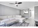 Modern living room with gray walls, hardwood floors, ceiling fan, and sectional sofa, plus views to the kitchen at 304 E South St # 5029, Orlando, FL 32801