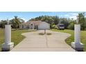 Well-maintained front yard with a circular driveway and stately entrance columns on a home with attached garage at 3871 Dallas Blvd, Orlando, FL 32833