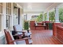 Spacious front porch featuring red tile floor and wooden chairs at 450 Cherokee Dr, Orlando, FL 32801