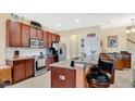 A kitchen featuring wood cabinets, stainless steel appliances, and granite countertops with barstool seating at 564 Woodland Terrace Blvd, Orlando, FL 32828