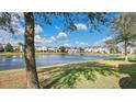 Community lake with fountain, lush green space, and townhomes in background at 564 Woodland Terrace Blvd, Orlando, FL 32828
