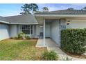 Charming front entrance with well-manicured landscaping and a seating chair for relaxation at 731 Red Coach Ave, Deltona, FL 32725
