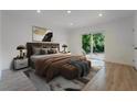Modern bedroom with a large bed, side tables, and a sliding glass door to the backyard at 1235 19Th St, Orlando, FL 32805