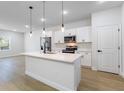 Modern kitchen features a central island with a sink, stainless steel appliances, and pendant lighting at 14962 Sw 39Th Cir, Ocala, FL 34473