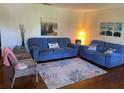 Living room features blue sofas, wicker chairs, and hardwood floors at 1520 Moravia Ave, Holly Hill, FL 32117