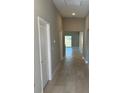 Hallway with gray walls, white trim and doors and neutral tile leading to other rooms in the home at 1621 Pear Ave, Sanford, FL 32771