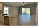 Open-concept layout with granite countertop, stainless steel appliances, and sliding glass door to the backyard at 1621 Pear Ave, Sanford, FL 32771