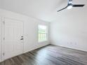 Bright living room with vinyl plank flooring, ceiling fan, and large window at 22474 Sw Rainbow Lakes Blvd, Dunnellon, FL 34431