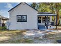 White house with gray accents, covered porch, and side yard at 805 Willow Ave, Sanford, FL 32771
