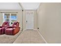 Home entryway with tiled floor and two red leather recliners at 11237 Amber Ridge Dr, Zellwood, FL 32798