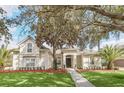Tan house with palm trees and a brick walkway at 1610 Conway Isle Cir, Belle Isle, FL 32809