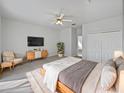 Spacious bedroom with wood-toned furniture and large TV at 304 Nottingham Way, Davenport, FL 33897