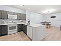 Modern kitchen with gray cabinets and white appliances at 3175 Feltrim Pl # 305, Kissimmee, FL 34747