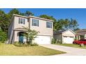 Two-story house with gray siding, white garage door, and blue shutters at 368 Pelham Park Dr, Deland, FL 32720