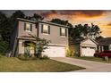 Two-story house with gray siding, white garage door, and blue shutters at dusk at 368 Pelham Park Dr, Deland, FL 32720