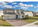 Two-story house with solar panels, three-car garage, and landscaped yard at 4360 Sunset Preserve Blvd, Orlando, FL 32820
