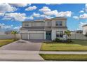 Two-story house with solar panels, three-car garage, and landscaped yard at 4360 Sunset Preserve Blvd, Orlando, FL 32820