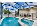 Screened pool and spa with comfortable seating area at 4973 Pall Mall W St, Kissimmee, FL 34758