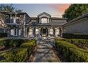 Two story house with a gray facade, lush landscaping, and a stone pathway at 6025 Lady Bet Dr, Orlando, FL 32819