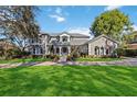 Elegant home with a manicured lawn and a circular driveway at 6025 Lady Bet Dr, Orlando, FL 32819
