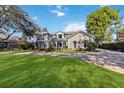 Elegant home with a manicured lawn and a circular driveway at 6025 Lady Bet Dr, Orlando, FL 32819