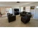 Open living room with terrazzo flooring, comfortable seating, and a large sliding door to the sunroom at 1456 N Page Dr, Deltona, FL 32725