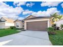 One story house with brown garage door and manicured lawn at 510 Canary Island Cir, Davenport, FL 33837