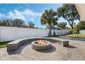 Beautiful backyard featuring a paver patio and a stone fire pit with integrated seating, perfect for outdoor entertaining at 604 Endsley Ave, Altamonte Springs, FL 32701