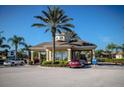Gated community entrance with guardhouse and lush landscaping at 8103 Coconut Palm Way # 105, Kissimmee, FL 34747